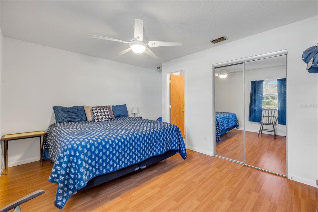 1981 South Merrick Drive Deltona, FL 32738 - Photo 13 of 30 a bedroom with a large bed and a chandelier