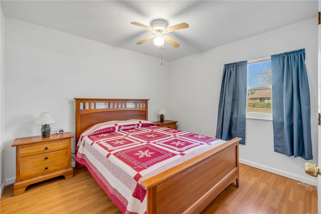 1981 South Merrick Drive Deltona, FL 32738 - Photo 17 of 30 a bedroom with a bed and a chandelier