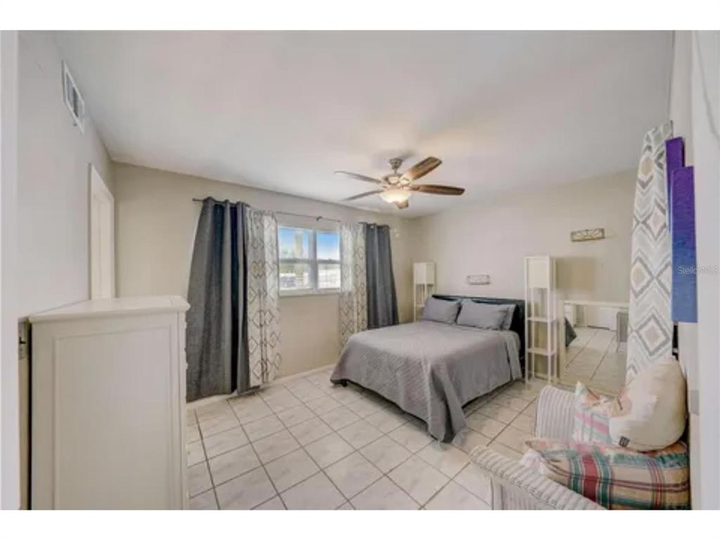 1433 South Belcher Road, Unit C1 Clearwater, FL 33764 - Photo 11 of 27 a bedroom with a bed and a chandelier