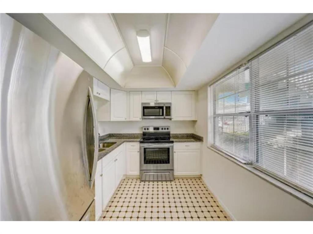 1433 South Belcher Road, Unit C1 Clearwater, FL 33764 - Photo 12 of 27 a kitchen with stainless steel appliances granite countertop a stove a sink and a refrigerator