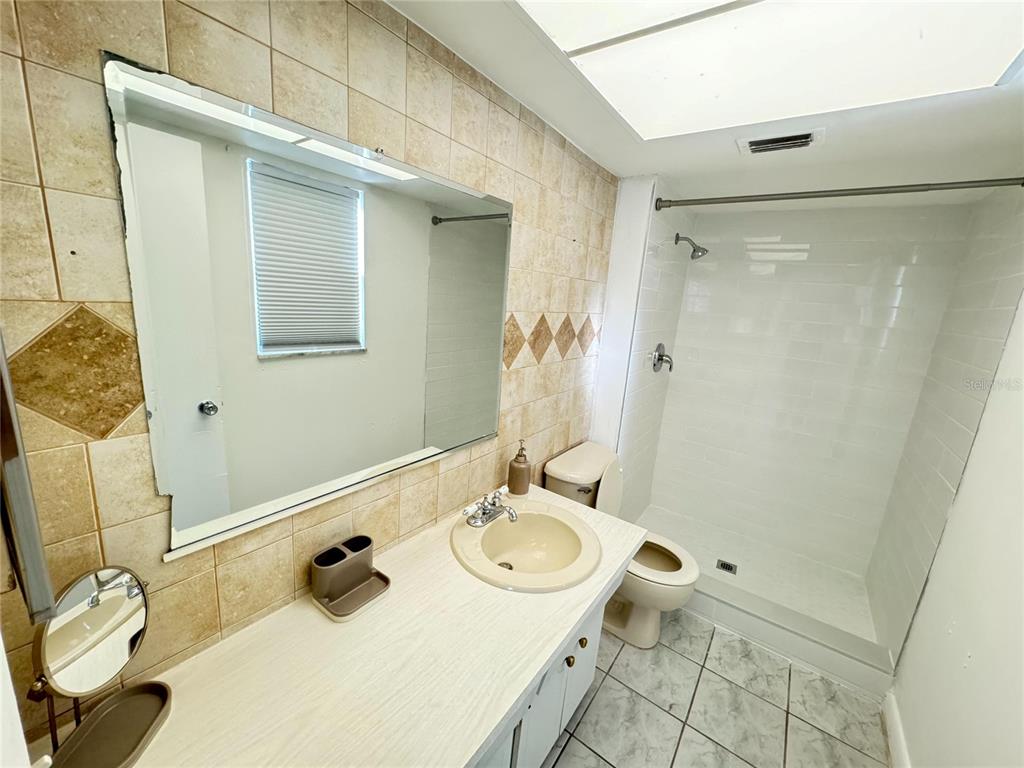 1433 South Belcher Road, Unit C1 Clearwater, FL 33764 - Photo 16 of 27 a bathroom with a granite countertop sink toilet and shower