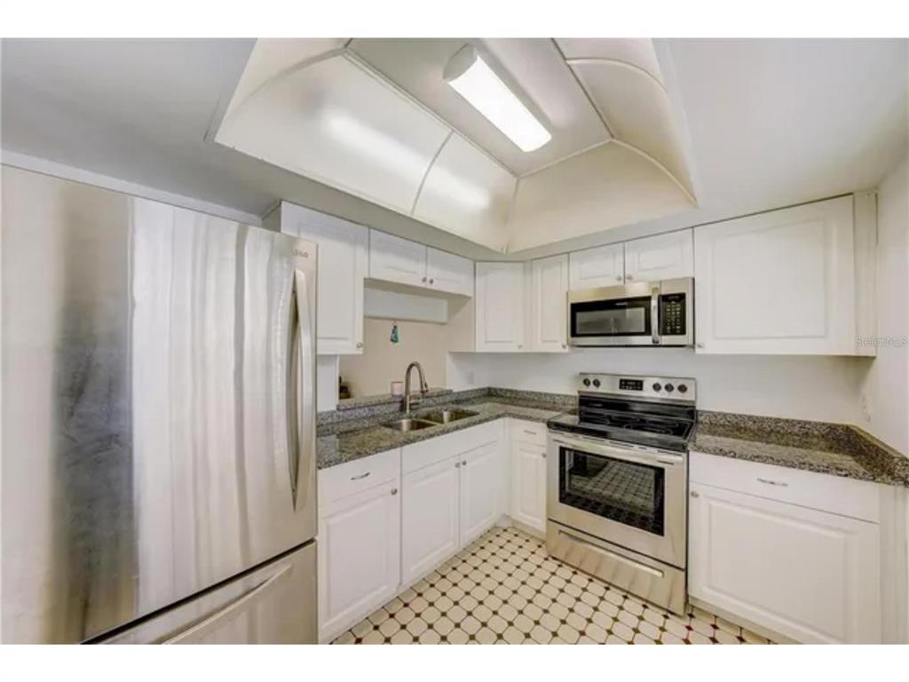 1433 South Belcher Road, Unit C1 Clearwater, FL 33764 - Photo 20 of 27 a kitchen with stainless steel appliances granite countertop a stove a sink and a microwave