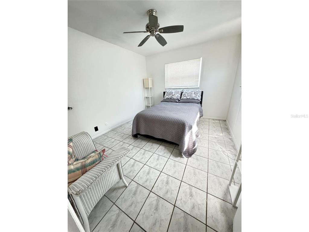 1433 South Belcher Road, Unit C1 Clearwater, FL 33764 - Photo 3 of 27 a bedroom with a bed and a chandelier