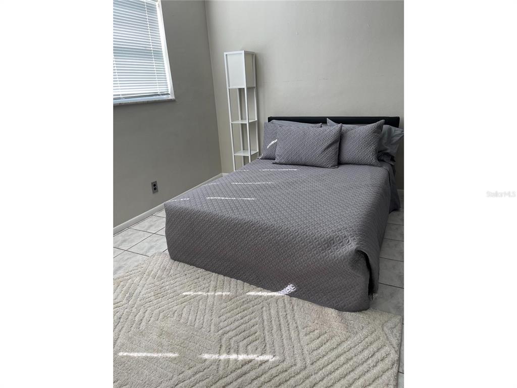 1433 South Belcher Road, Unit C1 Clearwater, FL 33764 - Photo 7 of 27 a bedroom with a bed and a window