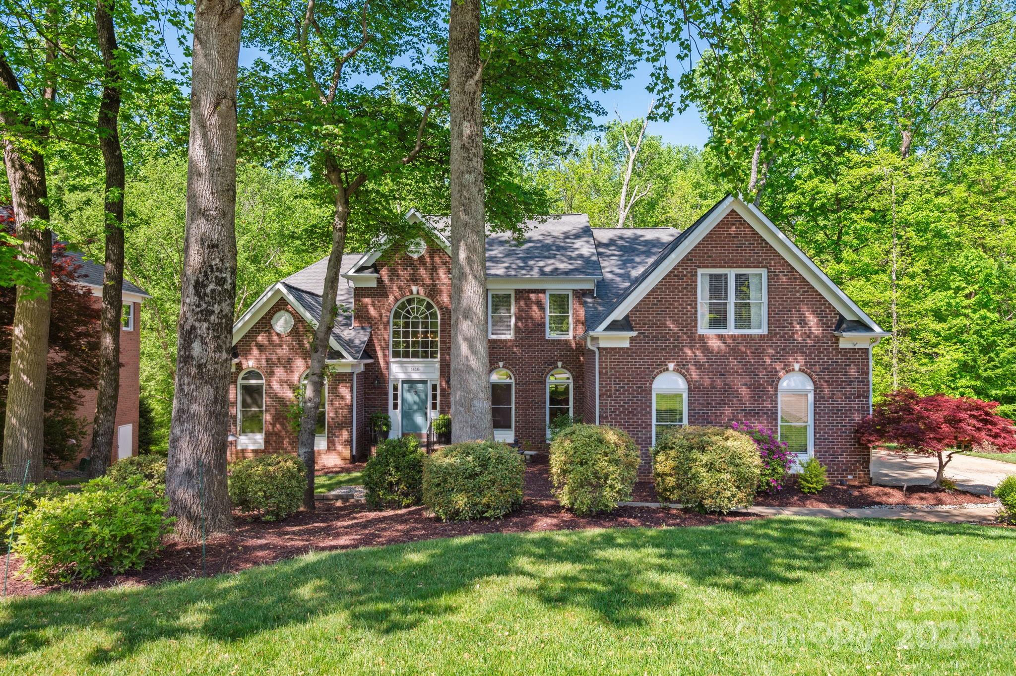 1418 Reverdy Oaks Drive Matthews, NC 28105 - Photo 2 of 45 a front view of a house with a yard and large trees