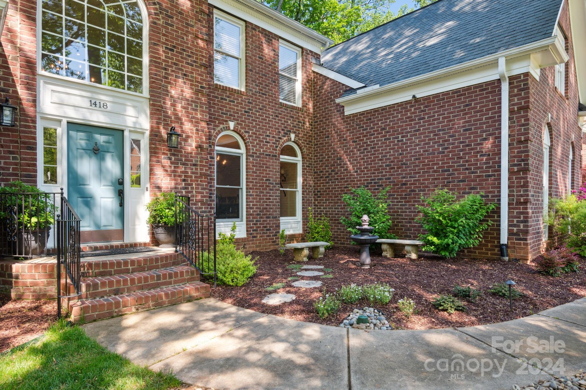 1418 Reverdy Oaks Drive Matthews, NC 28105 - Photo 3 of 45 a view of a brick house with many windows plants and large trees