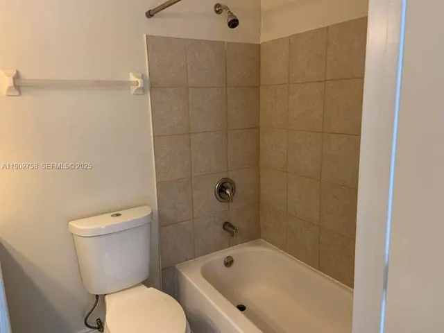 a white toilet sitting next to a bath tub