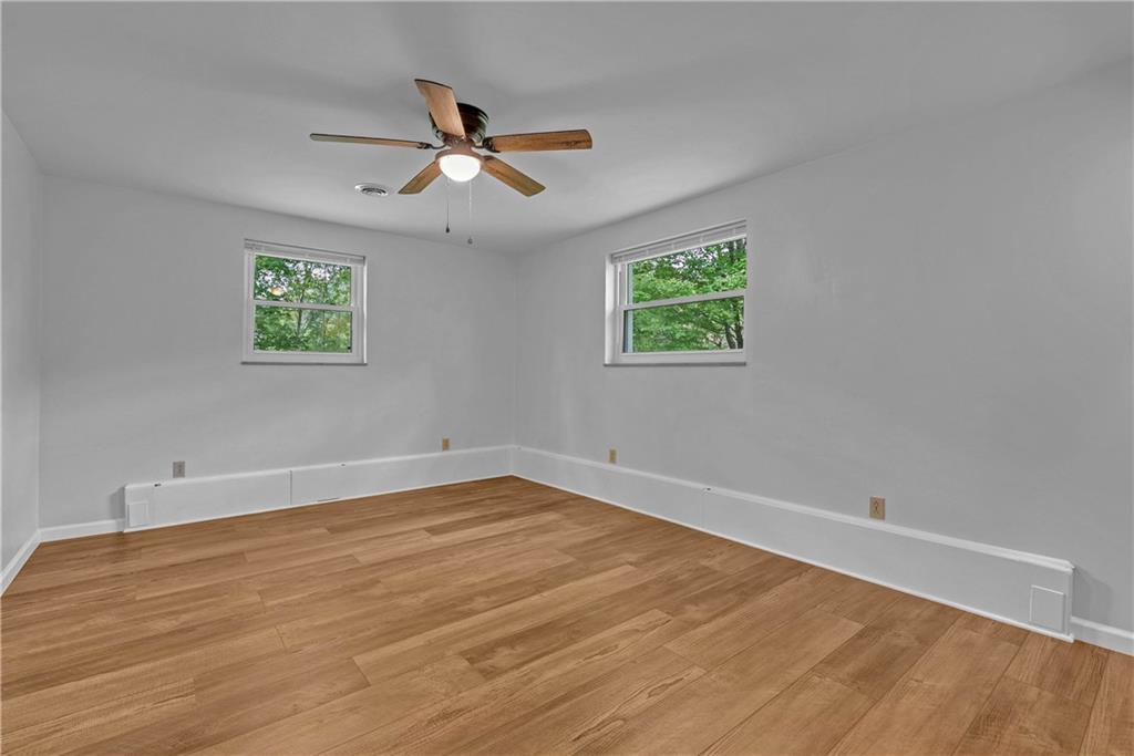 492 Center Grange Road Monaca, PA 15061 - Photo 17 of 36 an empty room with wooden floor ceiling fan and windows