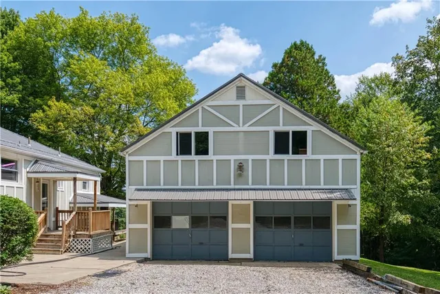 a view of a white house with large windows and a small yard