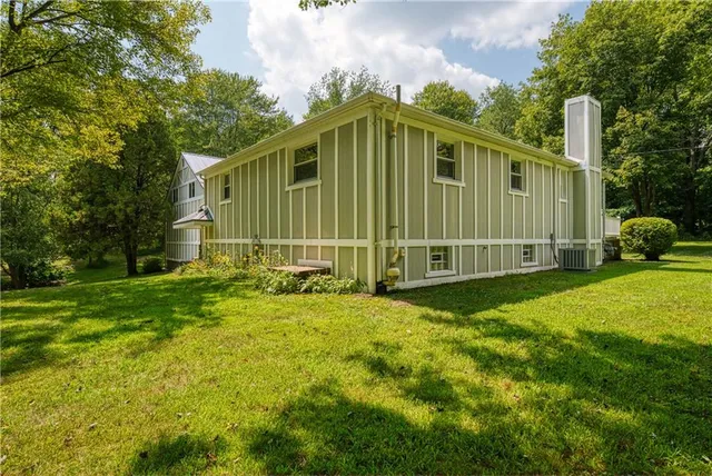 a view of a backyard with potted plants and large tree