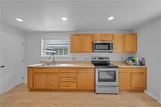 a kitchen with stainless steel appliances granite countertop a stove a sink and a microwave
