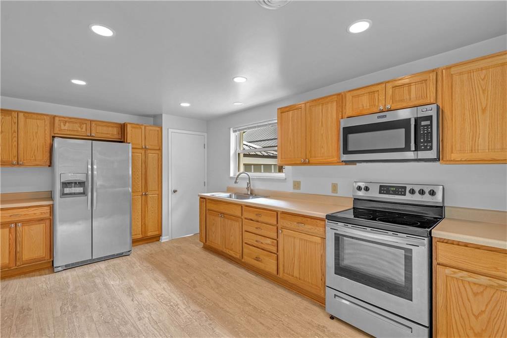 492 Center Grange Road Monaca, PA 15061 - Photo 7 of 36 a kitchen with stainless steel appliances granite countertop a stove a sink and a refrigerator