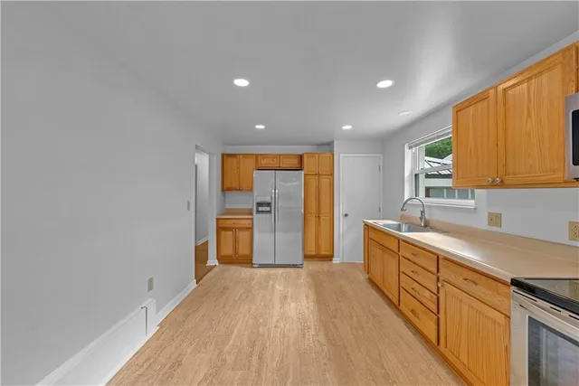 a view of a kitchen with wooden floor and electronic appliances