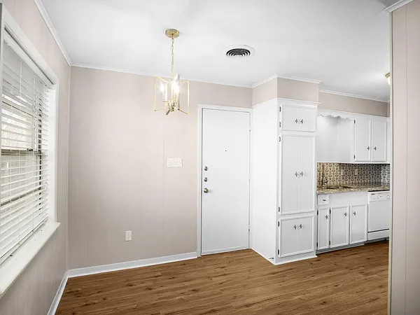 a view of a kitchen with wooden floor and window