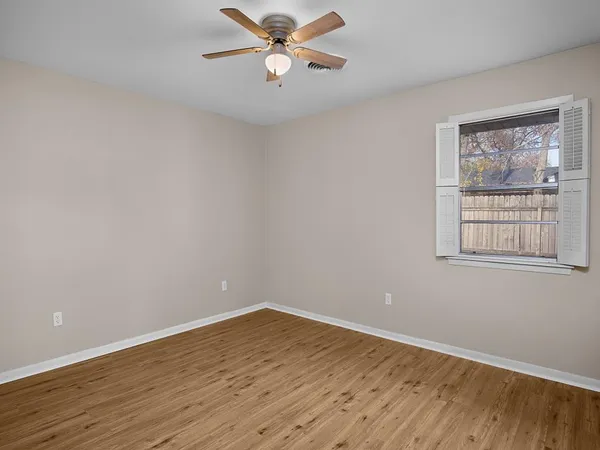 a view of a room with wooden floor and window