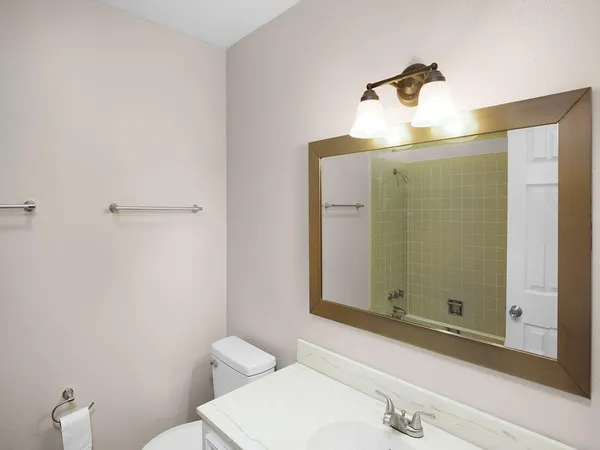 a bathroom with a sink and mirror with toilet