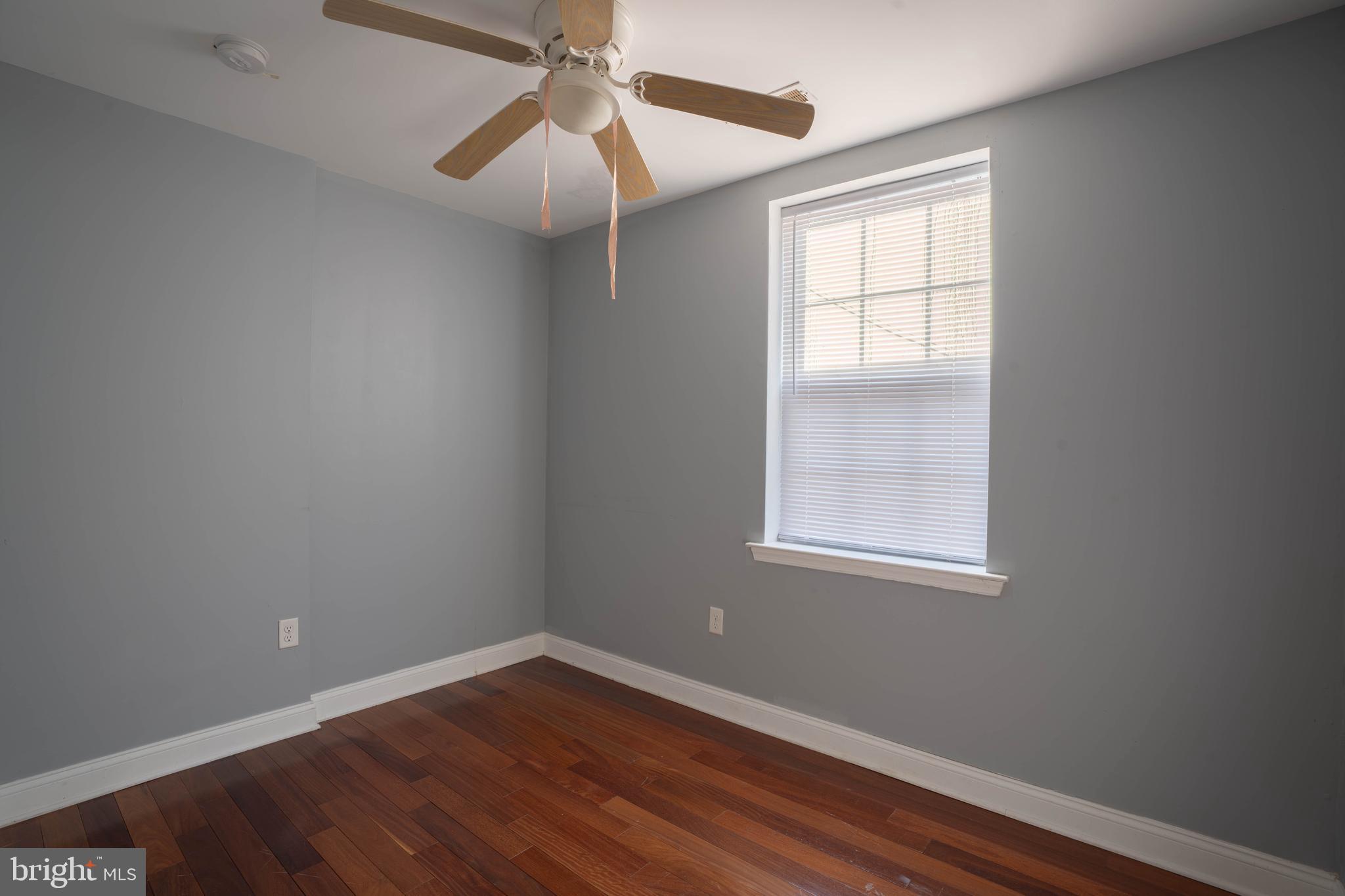 2212 North 16th Street, Unit 2 Philadelphia, PA 19132 - Photo 13 of 18 an empty room with wooden floor ceiling fan and windows
