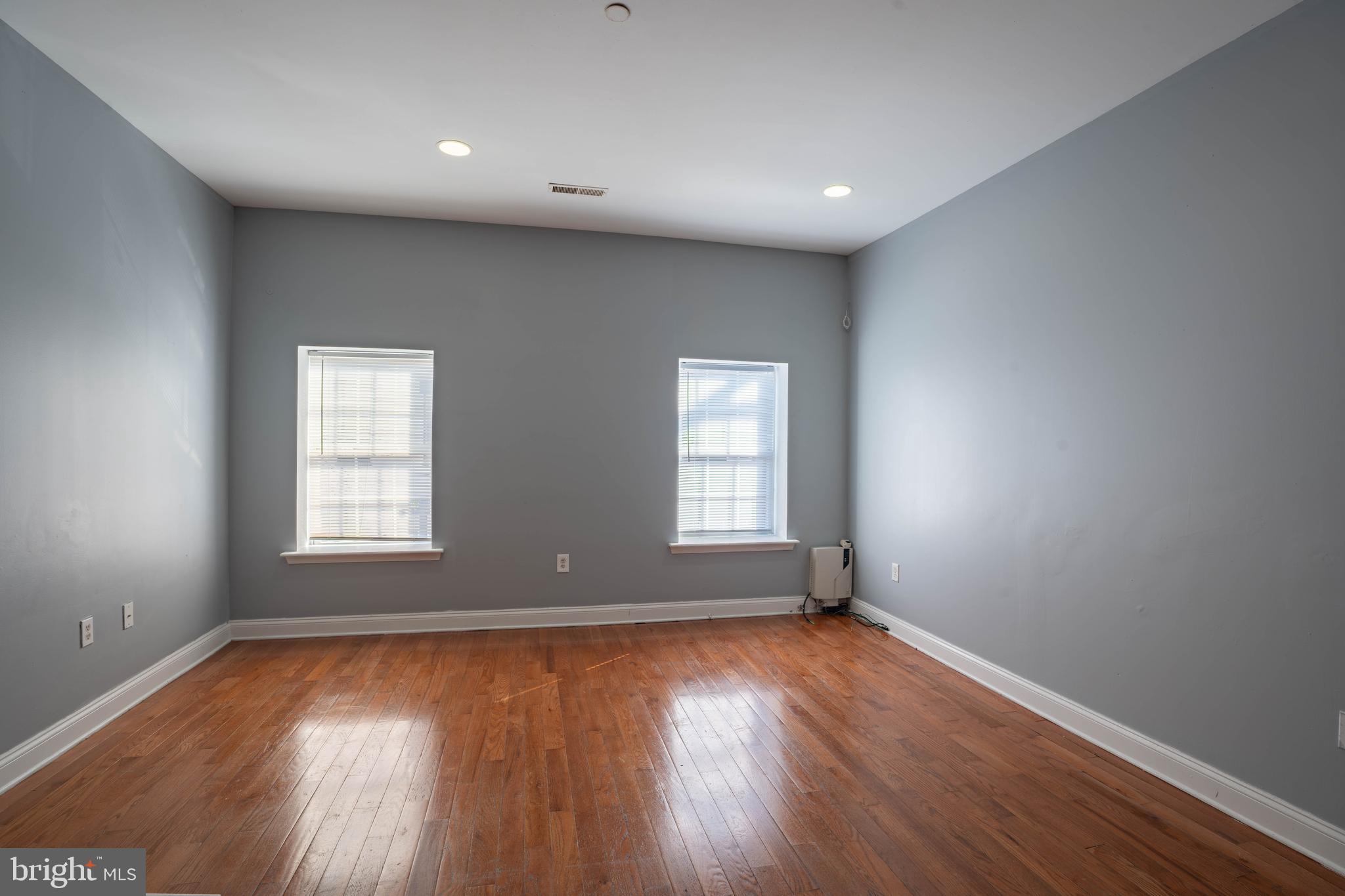 2212 North 16th Street, Unit 2 Philadelphia, PA 19132 - Photo 5 of 18 an empty room with wooden floor and windows