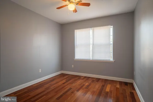 an empty room with a window and wooden floor