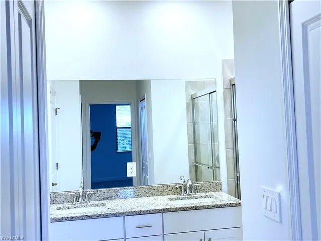 a bathroom with a granite countertop sink and a mirror