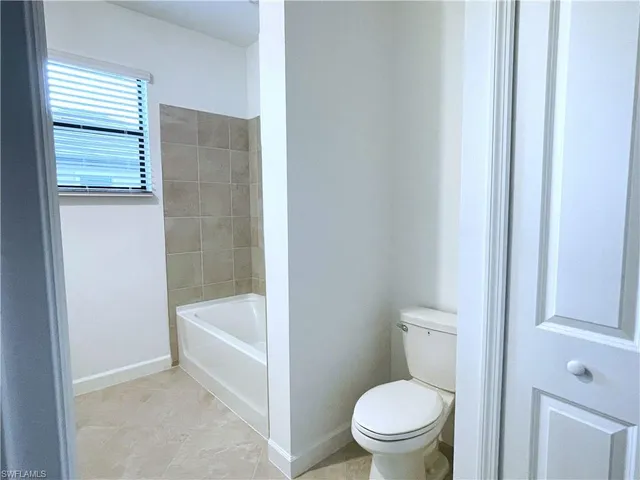 a white toilet sitting next to a bathtub