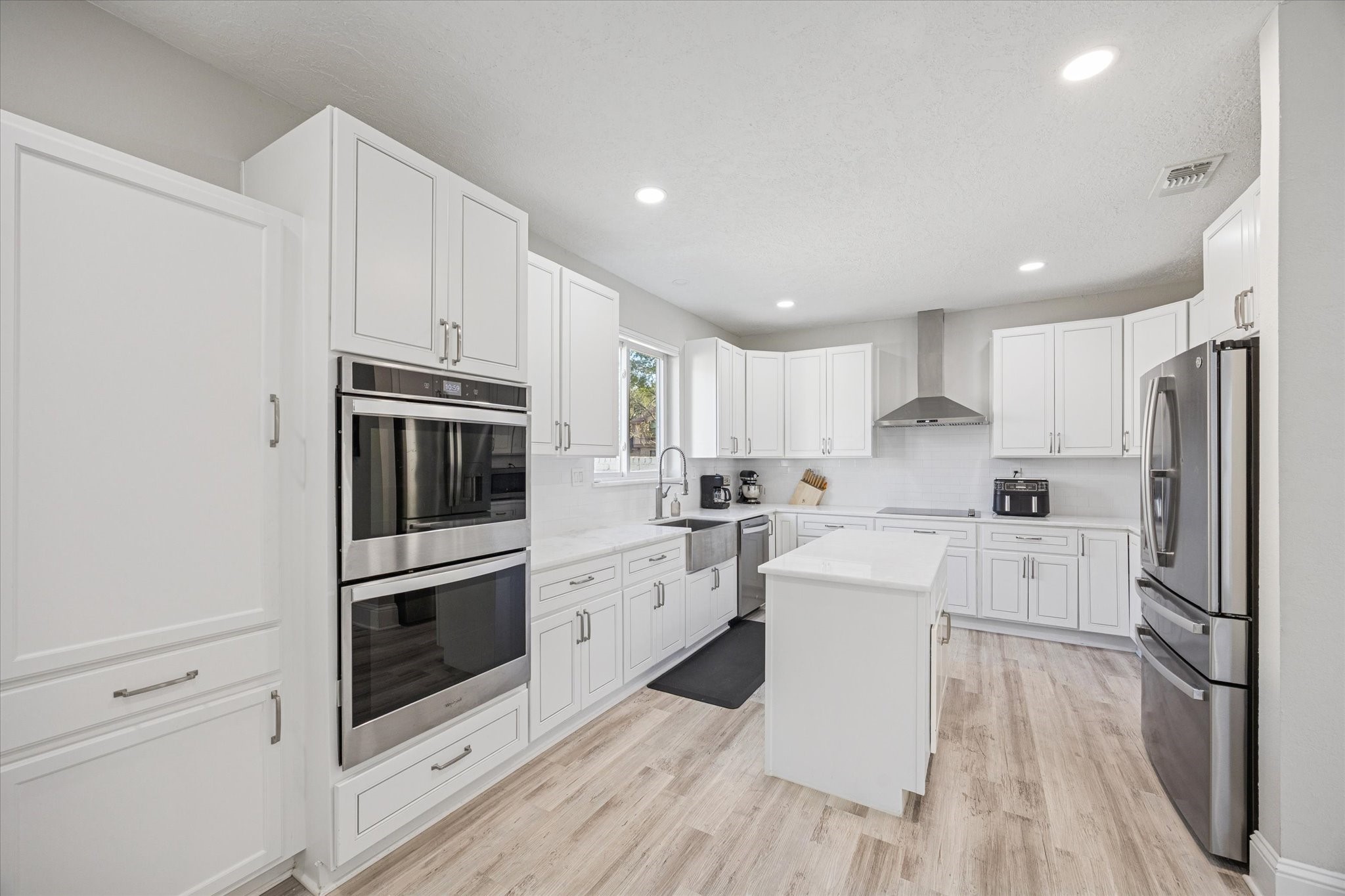 830 Silvergate Drive Houston, TX 77079 - Photo 16 of 38 a kitchen with white cabinets and stainless steel appliances