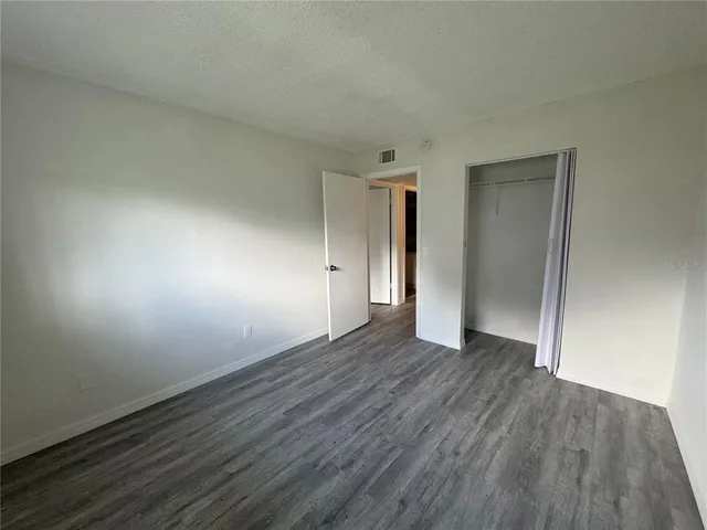 an empty room with wooden floor and closet