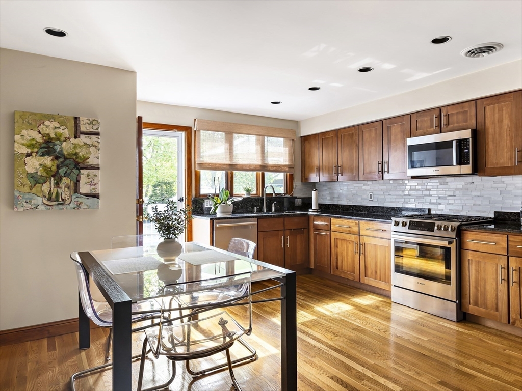 156 Woodcliff Road Newton, MA 02461 - Photo 2 of 17 a kitchen with granite countertop a stove a sink a dining table and chairs