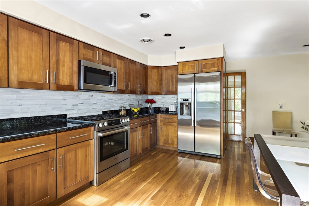 156 Woodcliff Road Newton, MA 02461 - Photo 3 of 17 a kitchen with stainless steel appliances granite countertop a stove a sink dishwasher a refrigerator and a microwave oven with wooden floor