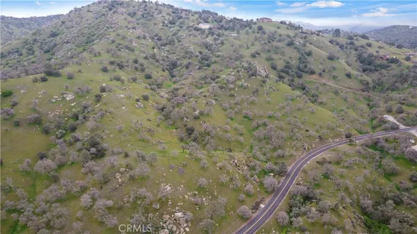 a view of a dry field with mountains in the background