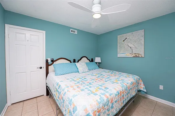 a bedroom with a large bed and a chandelier