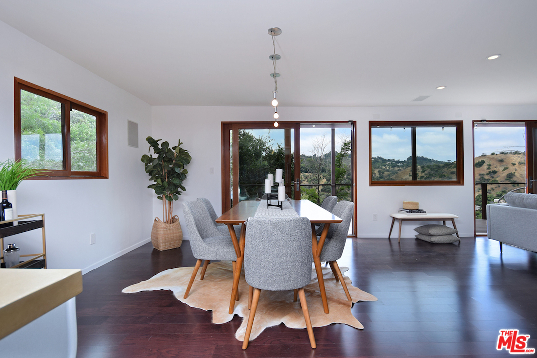 3605 Alta Mesa Drive Studio City, CA 91604 - Photo 19 of 47 a dining room with wooden floor a chandelier a glass table and chairs