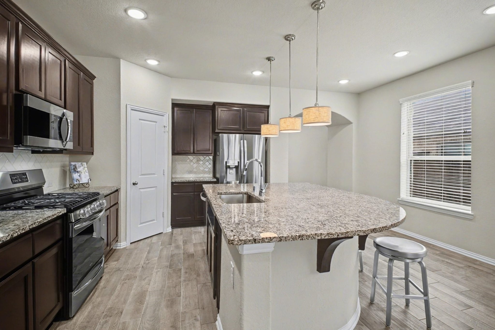 10602 Wagner Street Rosharon, TX 77583 - Photo 5 of 35 a kitchen with stainless steel appliances granite countertop a kitchen island hardwood floor sink stove dining table and chairs