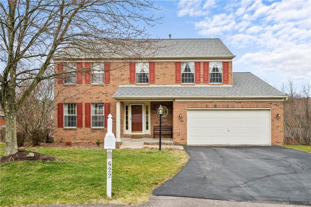 a front view of a house with a garden and yard