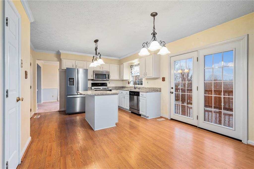 522 Leland Drive Pittsburgh, PA 15236 - Photo 8 of 22 a kitchen with stainless steel appliances kitchen island wooden floors and white cabinets
