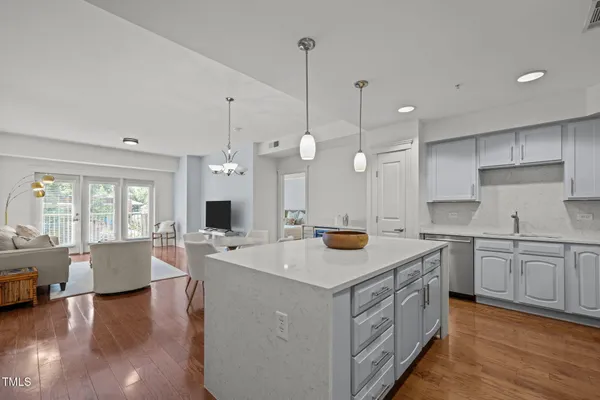 a kitchen that has a lot of cabinets a sink a stove and wooden floor