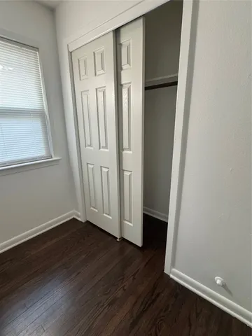 an empty room with wooden floor and a window