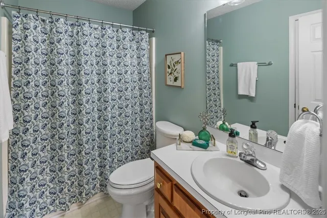 a white toilet sitting next to a shower curtain