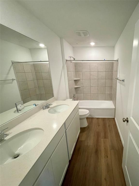 373 Jeffers Kyle, TX 78640 - Photo 13 of 26 Full bath with double vanity, bathtub / shower combination, and dark wood finished floors