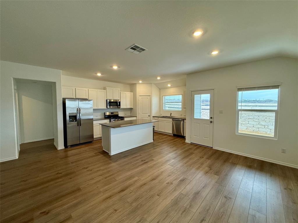 373 Jeffers Kyle, TX 78640 - Photo 4 of 26 Kitchen featuring stainless steel appliances, white cabinets, a center island, dark wood finished floors, and recessed lighting