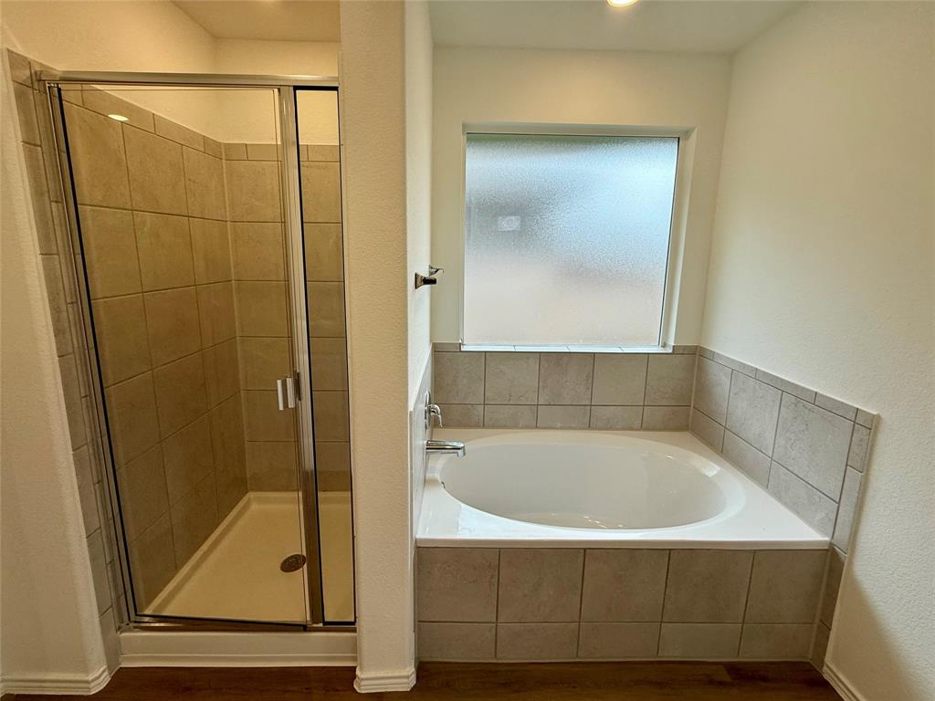 373 Jeffers Kyle, TX 78640 - Photo 10 of 26 Bathroom featuring a shower stall, a garden tub, and dark wood-style flooring