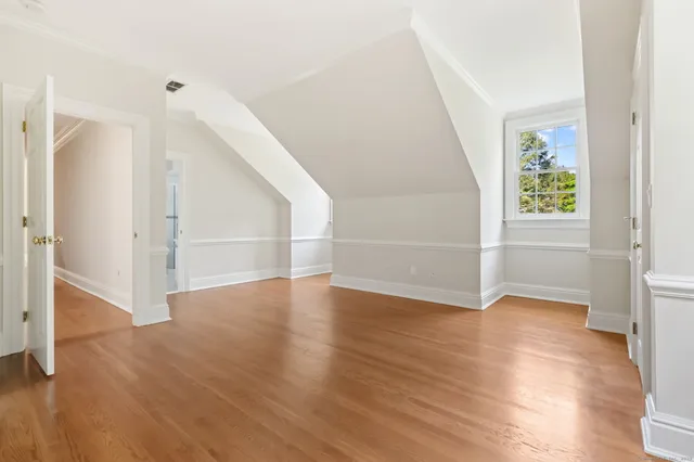 an empty room with wooden floor and entryway