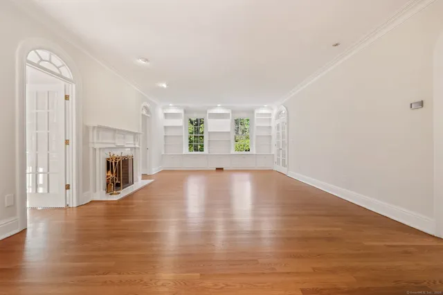 a view of empty room with wooden floor and fireplace