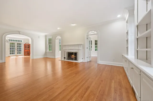 an empty room with wooden floor and fireplace