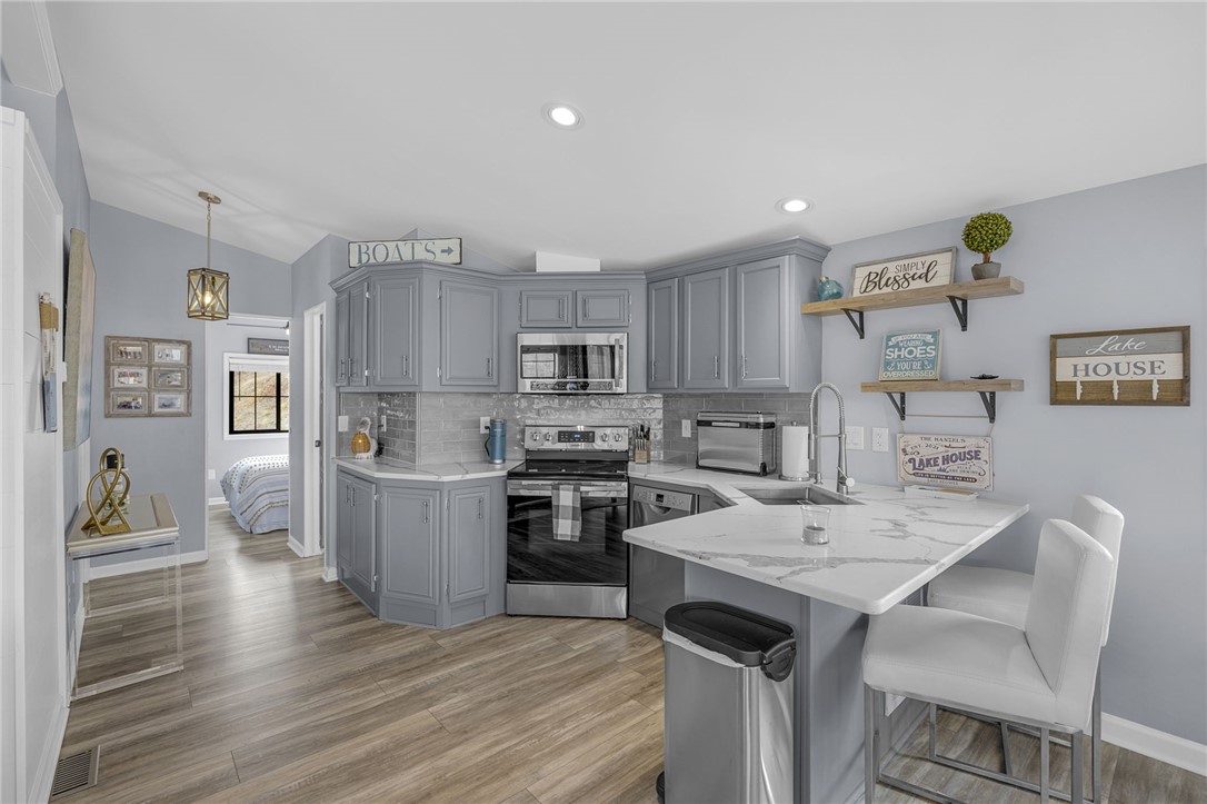 1230 Melton Road, Unit 15 West Union, SC 29696 - Photo 13 of 50 This modern kitchen features a breakfast bar, ample cabinet space, and durable flooring.