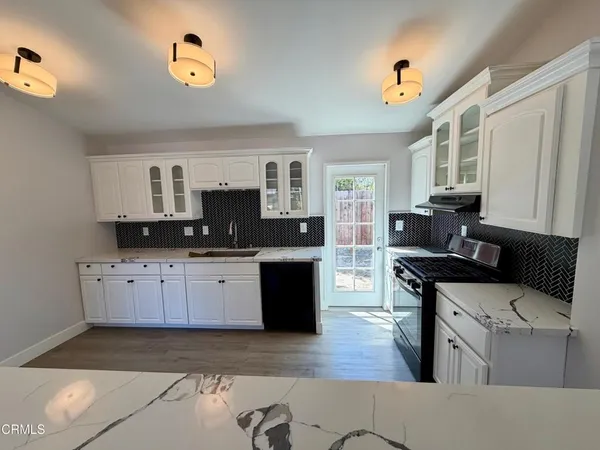 a kitchen with stainless steel appliances granite countertop a stove and a sink