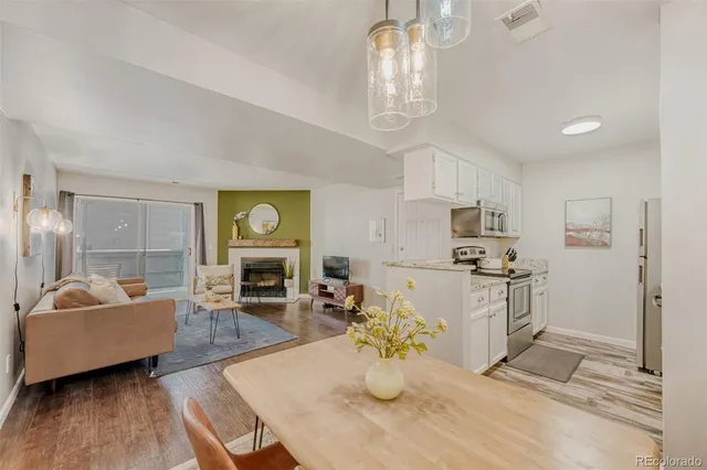 a view of a dining room with furniture a chandelier and wooden floor