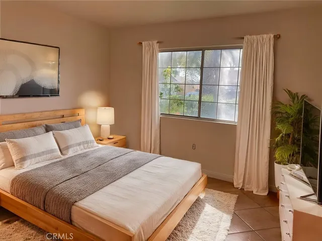 a bedroom with a bed and a flat screen tv