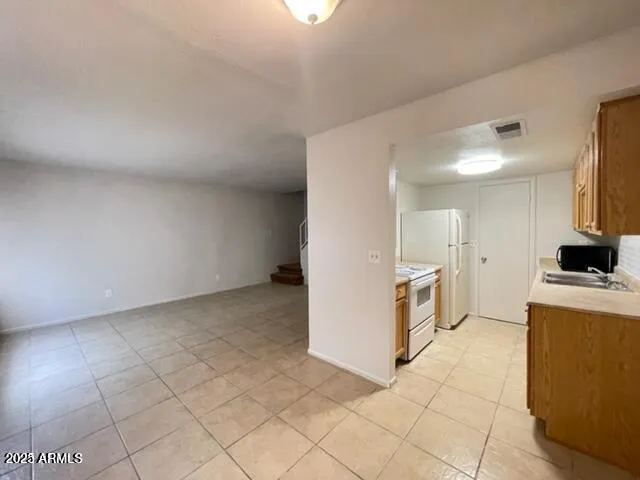 a view of a kitchen with fridge and wooden floor