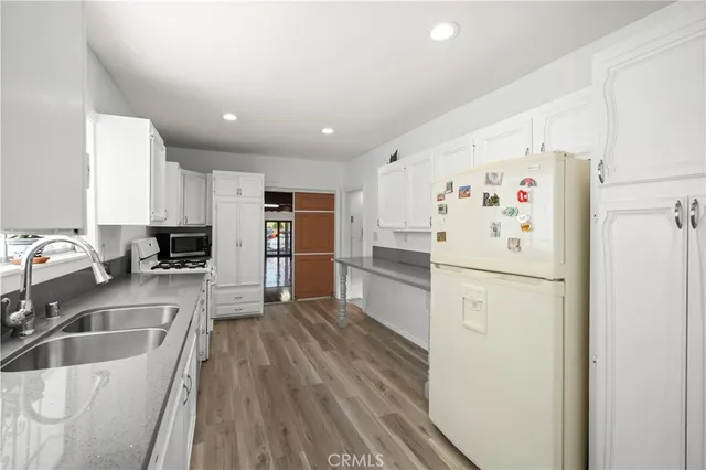 a kitchen with granite countertop a refrigerator and a sink